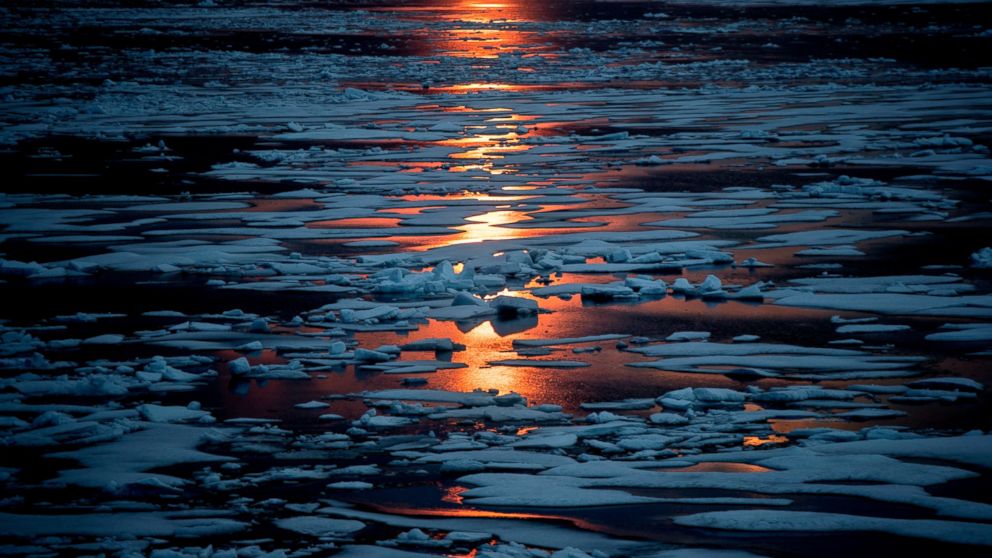 FILE- In this July 23, 2017, file photo the midnight sun shines across sea ice along the Northwest Passage in the Canadian Arctic Archipelago. The magnetic north pole is wandering about 34 miles (55 kilometers) a year. At the end of 2017 it crossed t