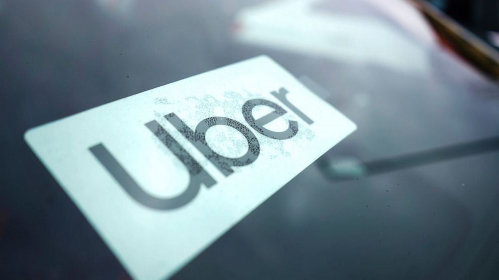 An Uber sign is displayed inside a car in Palatine, Ill., Thursday, Feb. 10, 2022. Uber has reached a deal to include New York City taxi cabs on its app, a move that will help to boost driver availability for passengers and open up a new set of custo