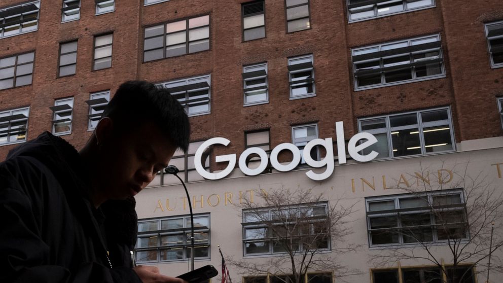 FILE - In this file photo dated Monday, Dec. 17, 2018, a man using a mobile phone walks past Google offices in New York. Monopoly or not, small business owners’ biggest complaint about Google is that its advertising policies favor companies with big 
