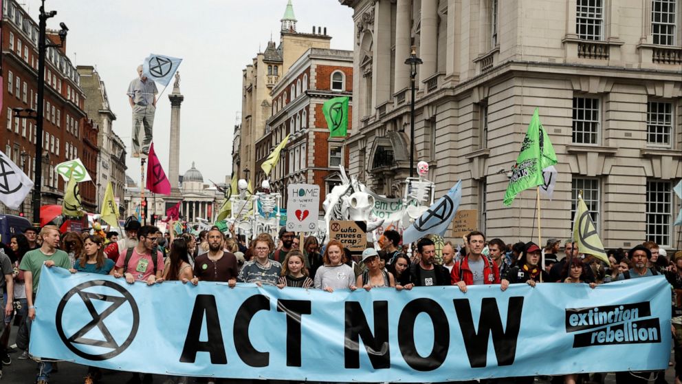 FILE - In this Tuesday April 23, 2019 file photo, climate change protesters march along Whitehall toward parliament, in London. Britain's prime minister has announced plans to eliminate the country's net contribution to climate change by 2050. Theres
