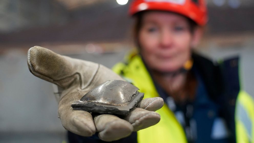 Susanne Rostmark, research leader, LKAB, holds a piece of hot briquetted iron ore made using the HYBRIT process nearby the venture’s pilot plant in Lulea, Sweden on Feb. 17, 2022. The steel-making industry is coming under increasing pressure to curb 