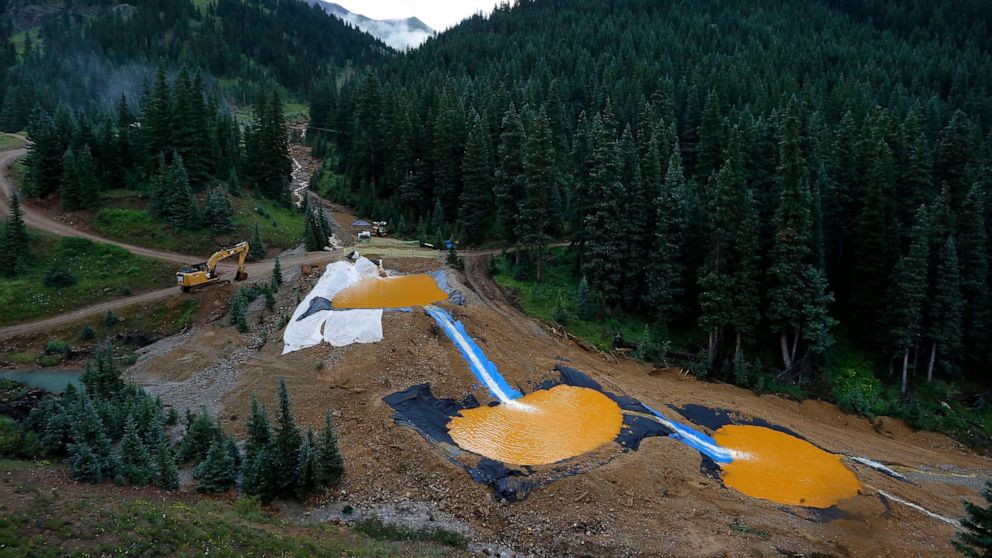 FILE - Wastewater flows through a series of retention ponds built to contain and filter out heavy metals and chemicals from the Gold King Mine in Silverton, Colo,. on Aug. 12, 2015. Colorado, the U.S. government and a gold mining company have agreed 