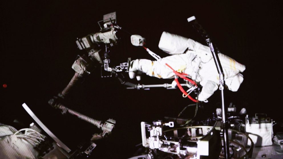 In this photo released by China's Xinhua News Agency, a screen at the Beijing Aerospace Control Center in Beijing shows Chinese astronaut Cai Xuzhe conducting extravehicular activities, also known as a spacewalk, around the space station lab module W