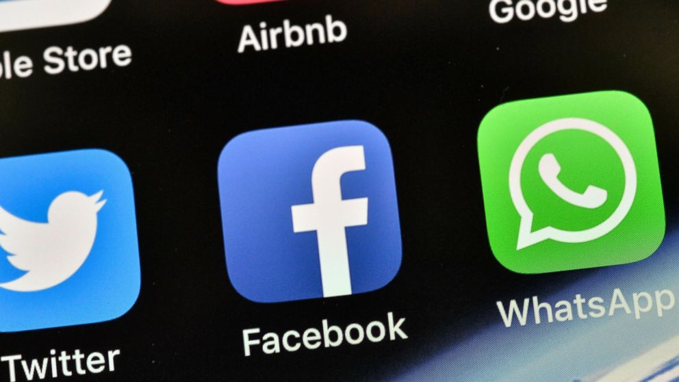 FILE - In this Nov. 15, 2018, file photo the icons of Facebook and WhatsApp are pictured on an iPhone in Gelsenkirchen, Germany. Mark Zuckerberg’s privacy memo is a maneuver to make more palatable the planned merging of the instant-messaging services