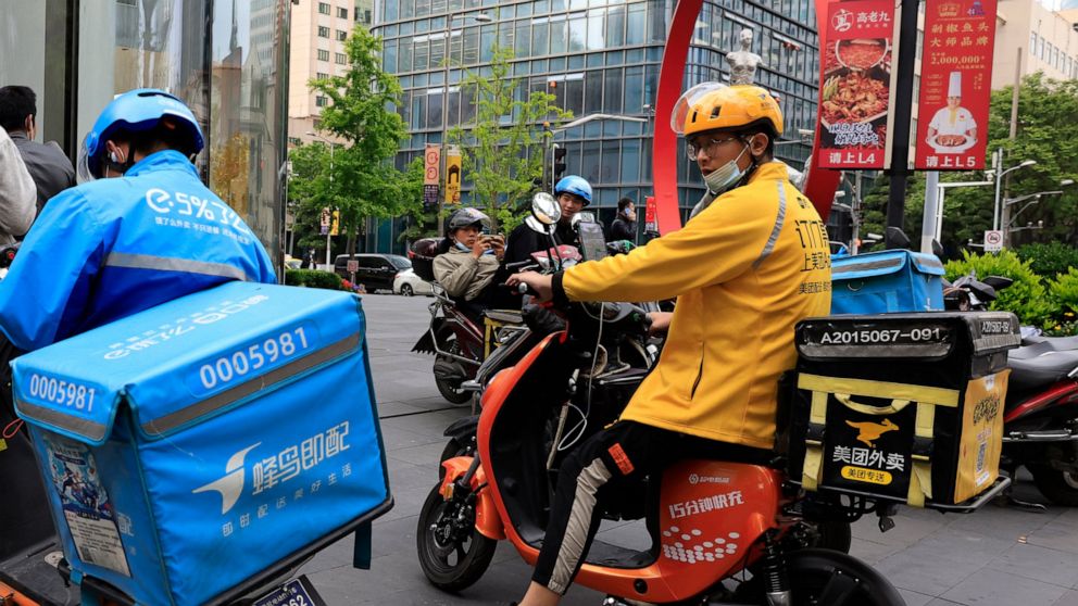 FILE - In this April 21, 2021, file photo, a Meituan delivery man in yellow goes on his rounds in Shanghai. Shares in Meituan, China’s largest food delivery platform, have tumbled Tuesday, May 11, 2021 after its CEO posted -and then deleted - an anci