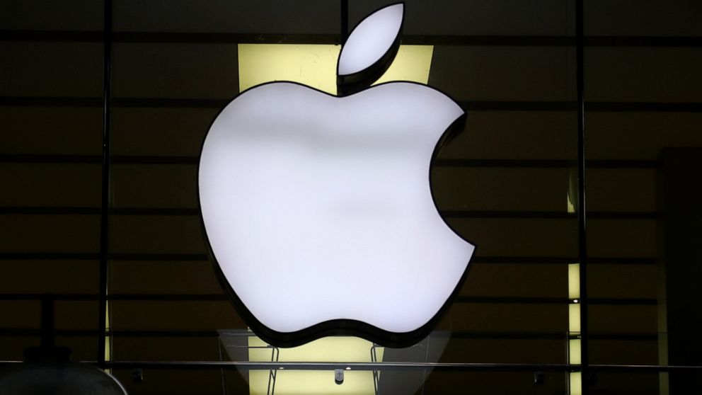 FILE - The logo of Apple is illuminated at a store in the city center in Munich, Germany, Wednesday, Dec. 16, 2020. Apple’s profit slipped during the past quarter of 2022, but the world’s largest technology company fared better than many of its peers