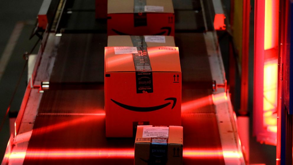 FILE - Packages riding on a belt are scanned to be loaded onto delivery trucks at the Amazon Fulfillment center in Robbinsville Township, N.J., on Aug. 1, 2017. Federal work-safety investigators are looking into the death of an Amazon worker and an i