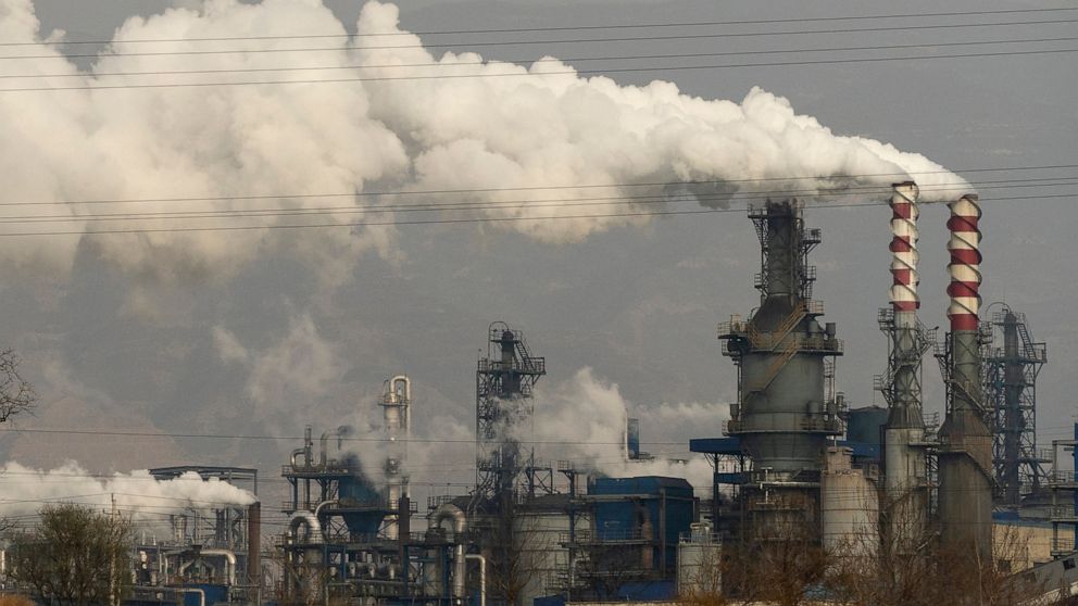 FILE - In this Nov. 28, 2019, file photo, smoke and steam rise from a coal processing plant in Hejin in central China's Shanxi Province. The International Energy Agency said Wednesday that emissions of planet-warming methane from oil, gas and coal pr