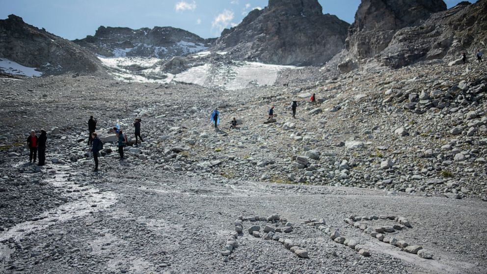The letters 'RIP' (rest in peace) are written with stones during a commemoration in front of the 'dying' glacier of Pizol mountain in Wangs, Switzerland, Sunday, Sept. 22, 2019. Various organizations gathered to shine a light on climate change and me