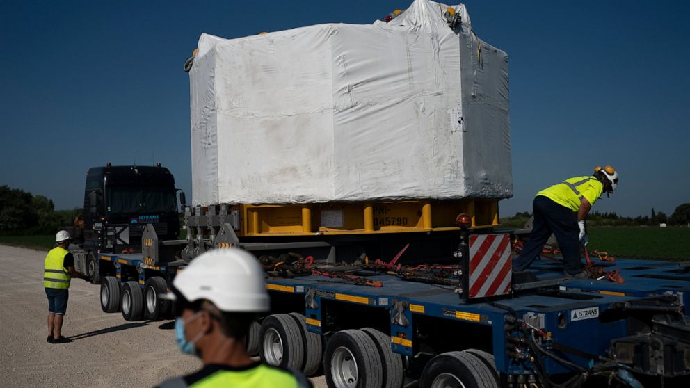 Workers secure a central solenoid magnet for the ITER project as it departs from Berre-l'Etang in southern France, Monday, Sept. 6, 2021. The first part of a massive magnet so strong its American manufacturer claims it can lift an aircraft carrier ar