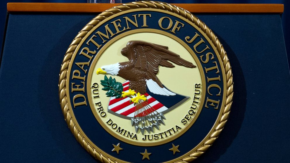 FILE - In this Nov. 28, 2018, file photo, the Department of Justice seal is seen in Washington, D.C. An internet firm is ending the automated registration of website names that include words or phrases related to the COVID-19 pandemic, in an attempt 
