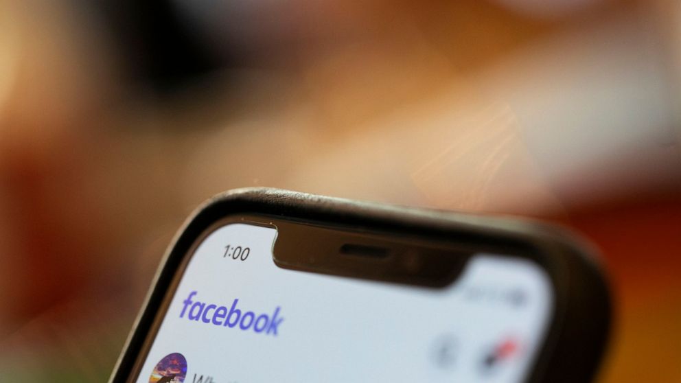 FILE - In this Aug. 11, 2019, file photo an iPhone displays a Facebook page in New Orleans. Facebook says hackers in China used fake accounts and impostor websites in a bid to break into the phones of Uyghur Muslims, Facebook announced Wednesday, Mar