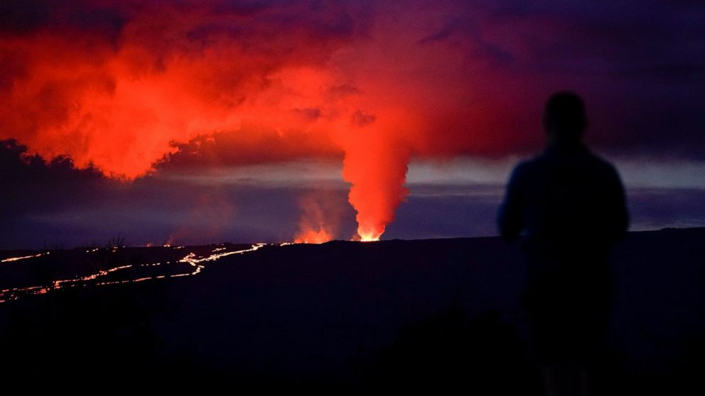 A man looks on as lava erupts from Hawaii's Mauna Loa volcano Wednesday, Nov. 30, 2022, near Hilo, Hawaii. (AP Photo/Gregory Bull)