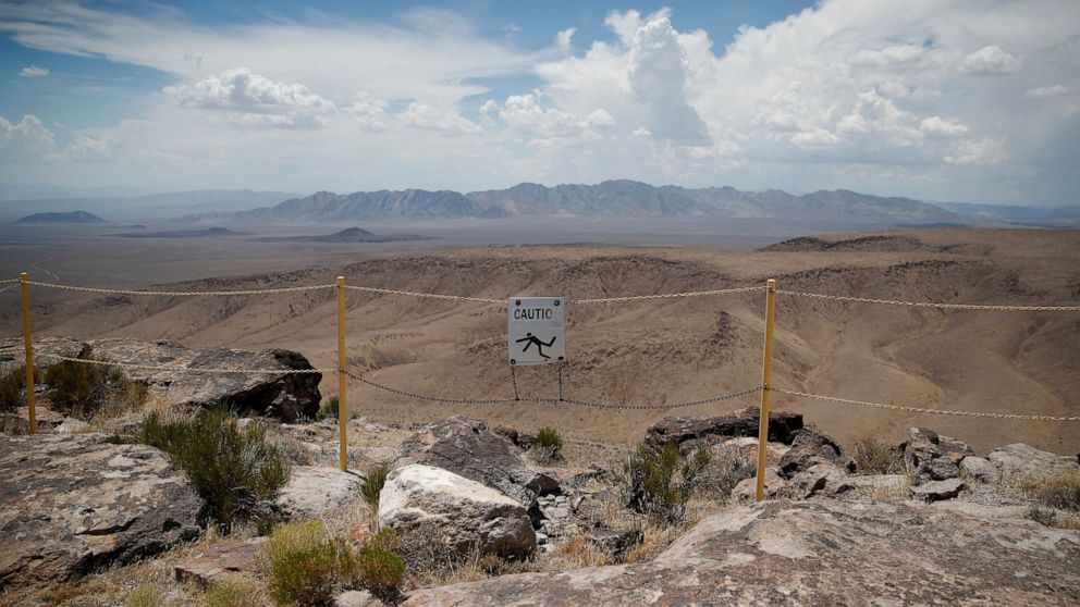 FILE - In this July 14, 2018, file photo, a sign warns of a falling danger on the crest of Yucca Mountain during a congressional tour near Mercury, Nev. Recent California earthquakes that rattled Las Vegas have shaken up arguments by proponents and o