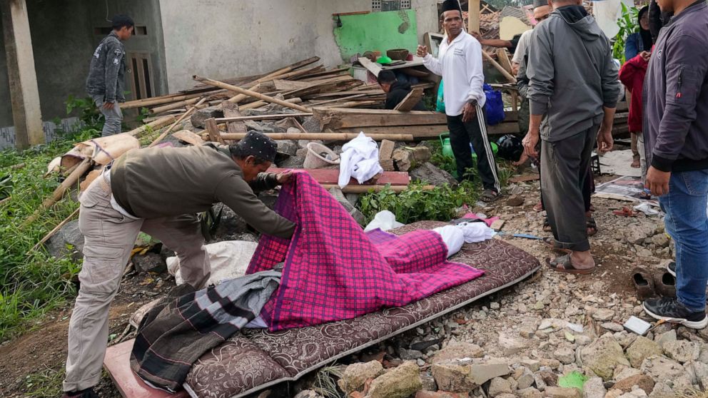 Family members prepare the body of a young earthquake victim for burial in Cianjur, West Java, Indonesia,T uesday, Nov. 22, 2022. Rescuers on Tuesday struggled to find more bodies from the rubble of homes and buildings toppled by an earthquake that k