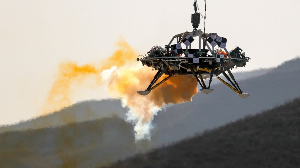 A lander is lifted during a test of hovering, obstacle avoidance and deceleration capabilities at a facility in Huailai in China's Hebei province, Thursday, Nov. 14, 2019. China has invited international observers to the test of its Mars lander as it