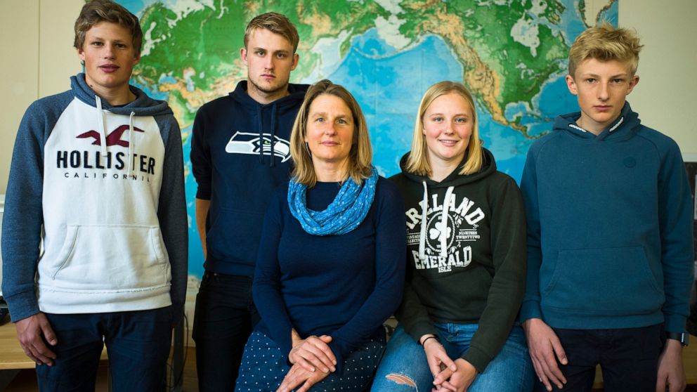 Silke Backsen, center poses with her children Hannes, left, Paul, second from left, Sophie second from right and Jakob, right, in front of a map of the world at the office of the environment organization Greenpeace in Berlin, Wednesday, Oct. 30, 2019