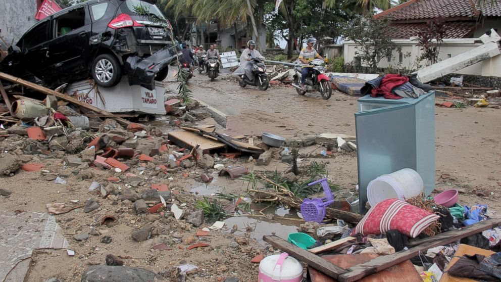 Motorists ride past debris following a tsunami in Anyar, Indonesia, Sunday, Dec. 23, 2018. An eruption of one of the world's most infamous volcanic islands is believed to have triggered a tsunami that killed hundreds of people in Indonesia during a busy holiday weekend. The waves smashed onto beaches at night without warning, ripping houses and hotels from their foundations in seconds and sweeping terrified concertgoers into the sea. (AP Photo)