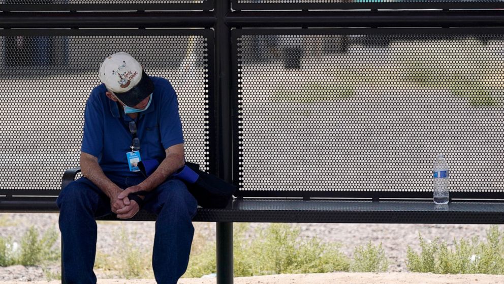 A person waits for a bus in the shade as the heat wave in the Western states continues Thursday, June 17, 2021, in Phoenix. (AP Photo/Ross D. Franklin)