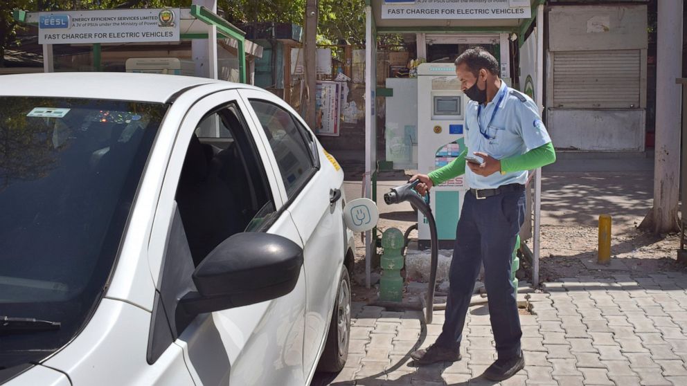 A driver of an electric car charges his vehicle at public charging station in New Delhi, India, Thursday, April 1, 2021. India has ambitions to expand use of electric vehicles to wean itself from polluting fossil fuels, but EVs are still a rarity on 
