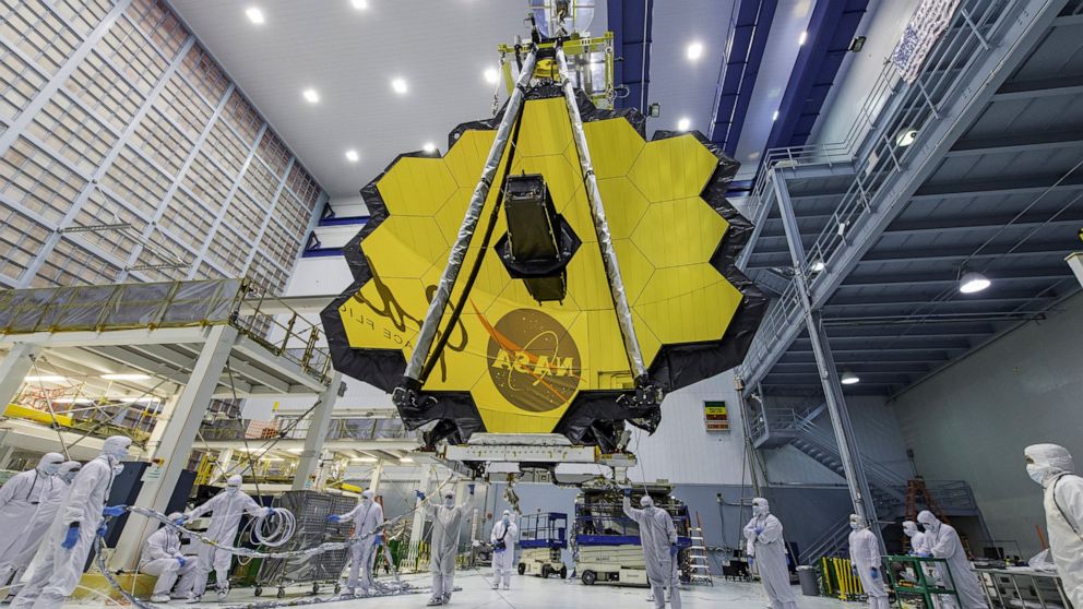 FILE - In this April 13, 2017 photo provided by NASA, technicians lift the mirror of the James Webb Space Telescope using a crane at the Goddard Space Flight Center in Greenbelt, Md. NASA announced Tuesday, Dec. 14, 2021, that next week’s launch of i