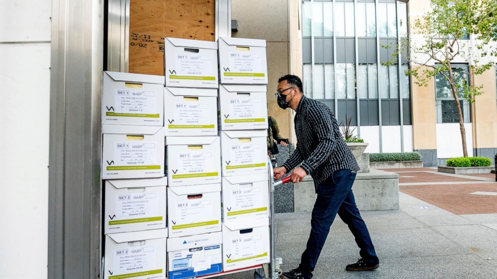 A member of Apple's legal team rolls exhibit boxes into the Ronald V. Dellums building in Oakland, Calif., as the company faces off in federal court against Epic Games on Monday, May 3, 2021. Epic, maker of the video game Fortnite, charges that Apple