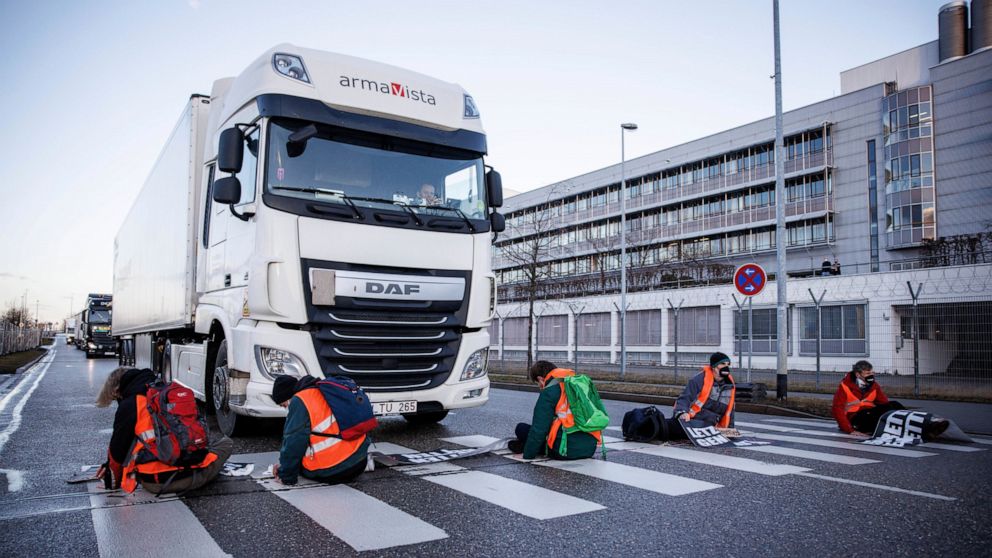 Climate activists of the group Uprising of the Last Generation stuck their hands on a crosswalk to block an access road to the cargo area from Munich Airport in Munich, Germany, Wednesday, Feb. 23, 2022. (Matthias Balk/dpa via AP)