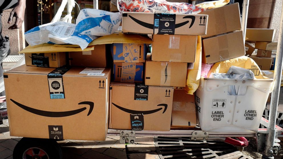 FILE - In this Oct. 10, 2018, file photo, Amazon Prime boxes are loaded on a cart for delivery in New York. Amazon said Tuesday, June 23, 2020, that its carbon footprint rose 15% last year, even as it launched initiatives to reduce its harm on the en