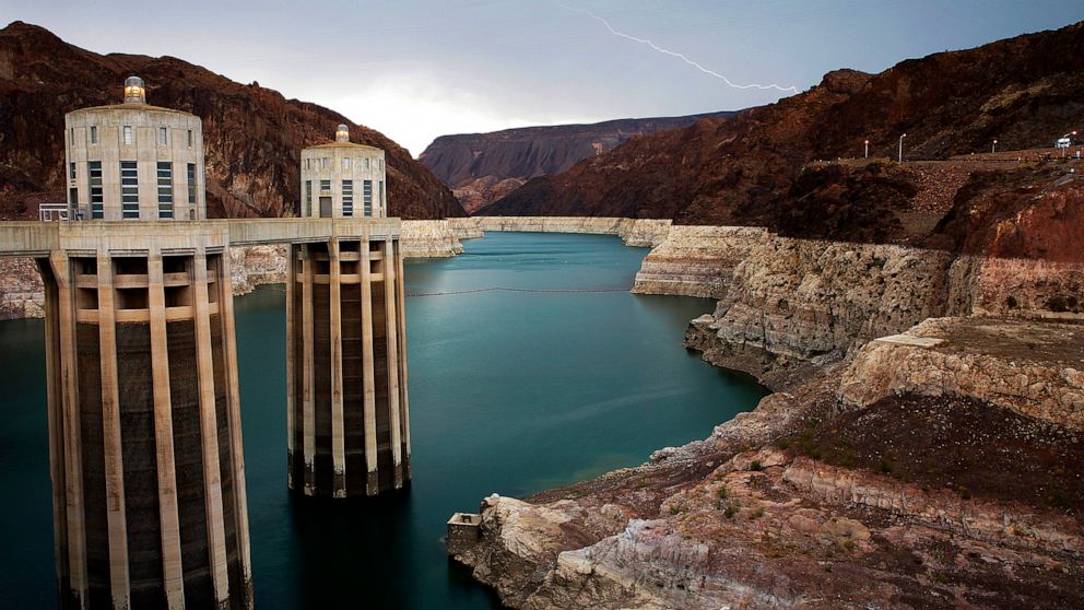 FILE - In this July 28, 2014, file photo, lightning strikes over Lake Mead near Hoover Dam that impounds Colorado River water at the Lake Mead National Recreation Area in Arizona. The Bureau of Reclamation is forecasting first-ever water shortages be