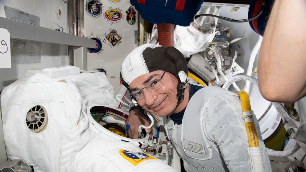 In this Aug. 17, 2021 photo made available by NASA, astronaut and Expedition 65 Flight Engineer Mark Vande Hei inspects a spacesuit in preparation for a spacewalk at the International Space Station. On Monday, Aug. 23, NASA announced it is delaying a