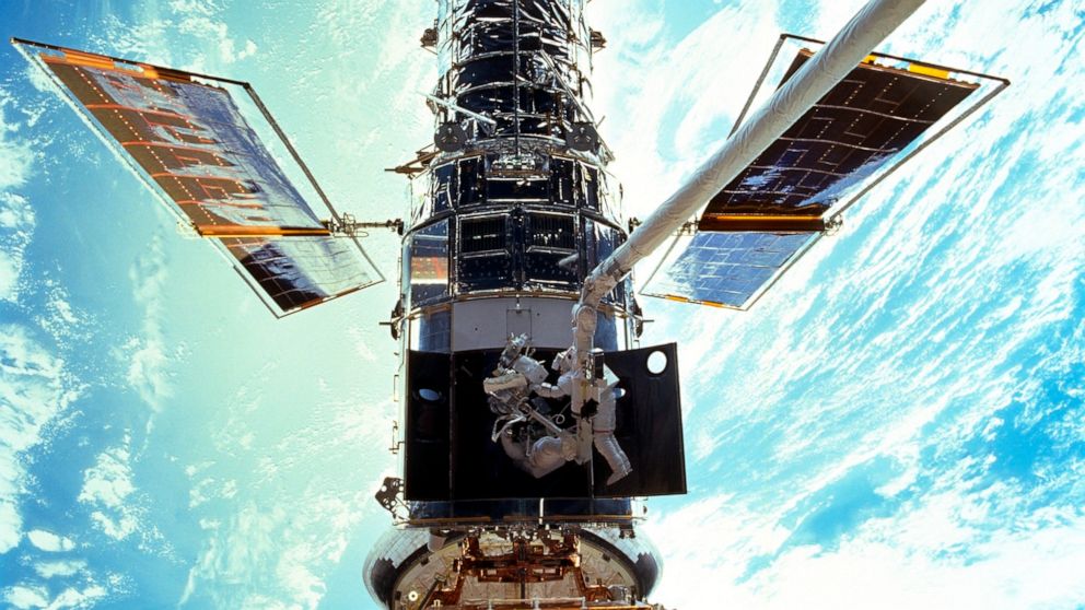 FILE - In this image provided by NASA/JSC, astronauts Steven L. Smith and John M. Grunsfeld are photographed during an extravehicular activity (EVA) during the December 1999 Hubble servicing mission of STS-103, flown by Discovery. The Hubble Space Te