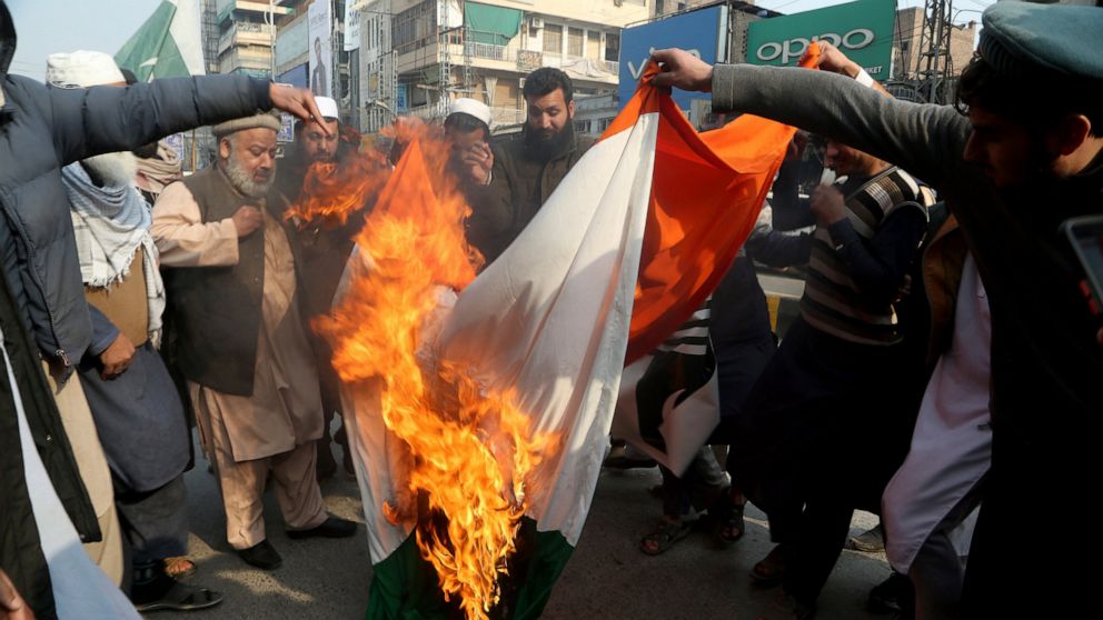 Pakistani traders burn a representation of Indian flag during demonstration to mark Kashmir Solidarity Day, in Peshawar, Pakistan, Friday, Feb. 5, 2021. Pakistan's political and military leadership on Friday marked the annual Day of Solidarity with K