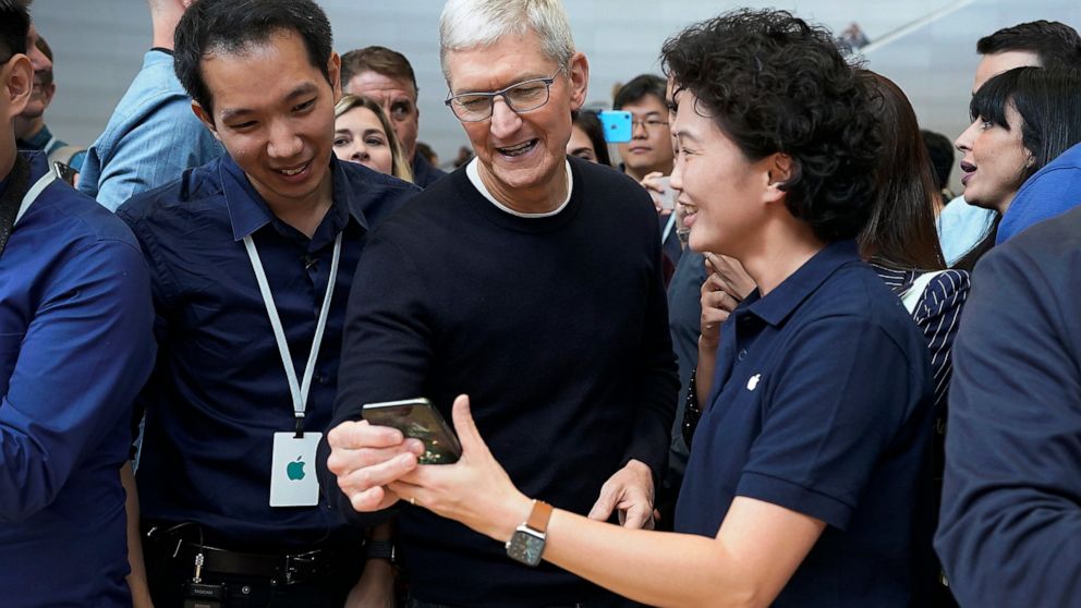 Apple CEO Tim Cook, center, looks at the the new iPhone 11 Pro Max, during an event to announce new products Tuesday, Sept. 10, 2019, in Cupertino, Calif. (AP Photo/Tony Avelar)