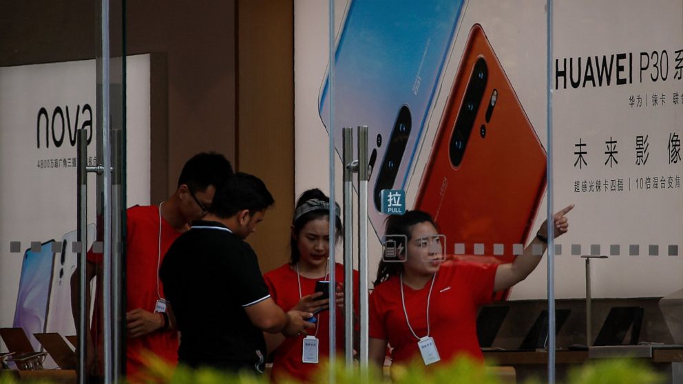 Staffers help a tourist search for directions at a Huawei retail store in Beijing, Tuesday, June 11, 2019. Chinese tech giant Huawei said Tuesday it would have become the world's number one smartphone maker by year's end if it were not for "unexpecte