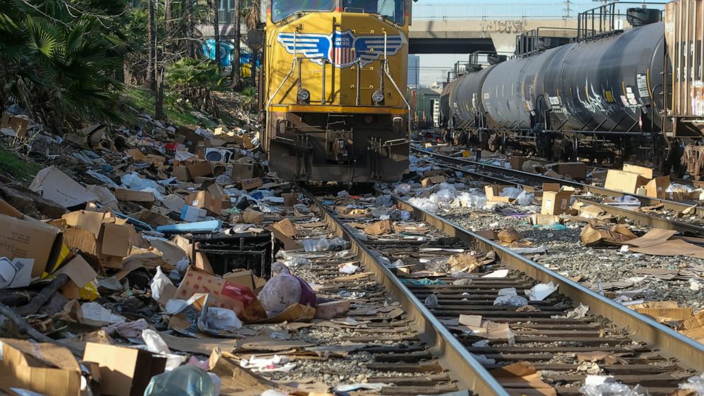 Shredded boxes and packages are seen at a section of the Union Pacific train tracks in downtown Los Angeles Friday, Jan. 14, 2022. Thieves have been raiding cargo containers aboard trains nearing downtown Los Angeles for months, leaving the tracks bl