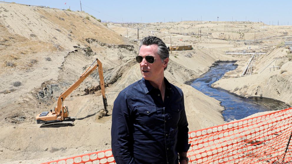 FILE - In this July 24, 2019, file photo, Gov. Gavin Newsom tours the Chevron oil field west of Bakersfield where a spill of more than 800,000 gallons flowed into a dry creek bed in McKittrick, Calif. Newsom's administration has temporarily banned ne
