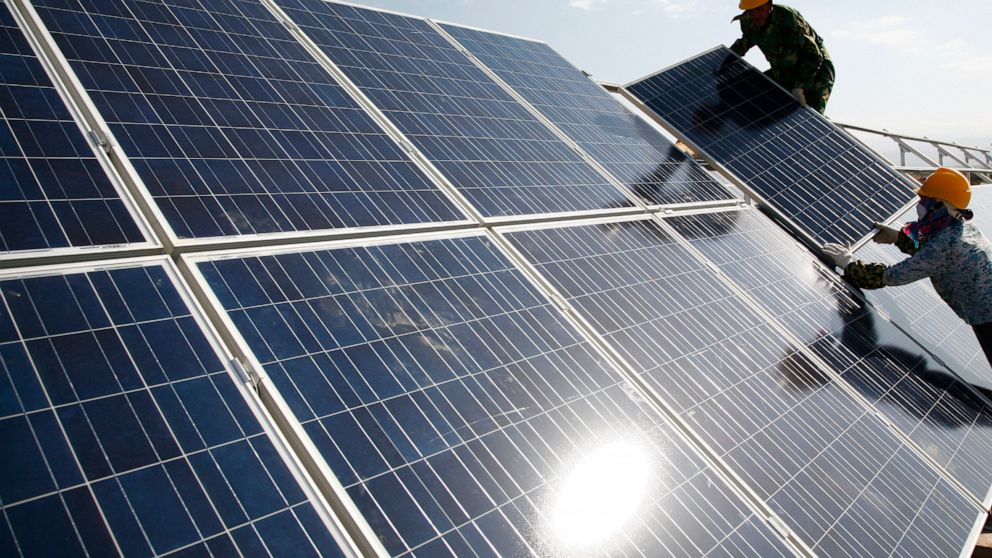 Workers install solar panels at a photovoltaic power station in Hami in northwestern China's Xinjiang Uyghur Autonomous Region Monday Aug. 22, 2011. The Biden administration's solar power ambitions are colliding with complaints the global industry de