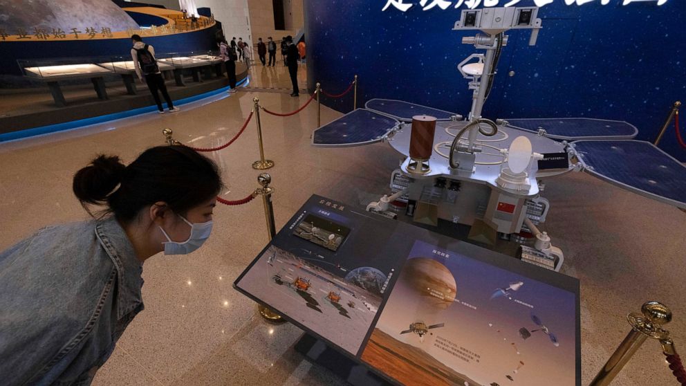 A visitor to an exhibition on China's space program looks at a life size model of the Chinese Mars rover Zhurong, named after the Chinese god of fire, at the National Museum in Beijing on Thursday, May 6, 2021. China has landed a spacecraft on Mars f
