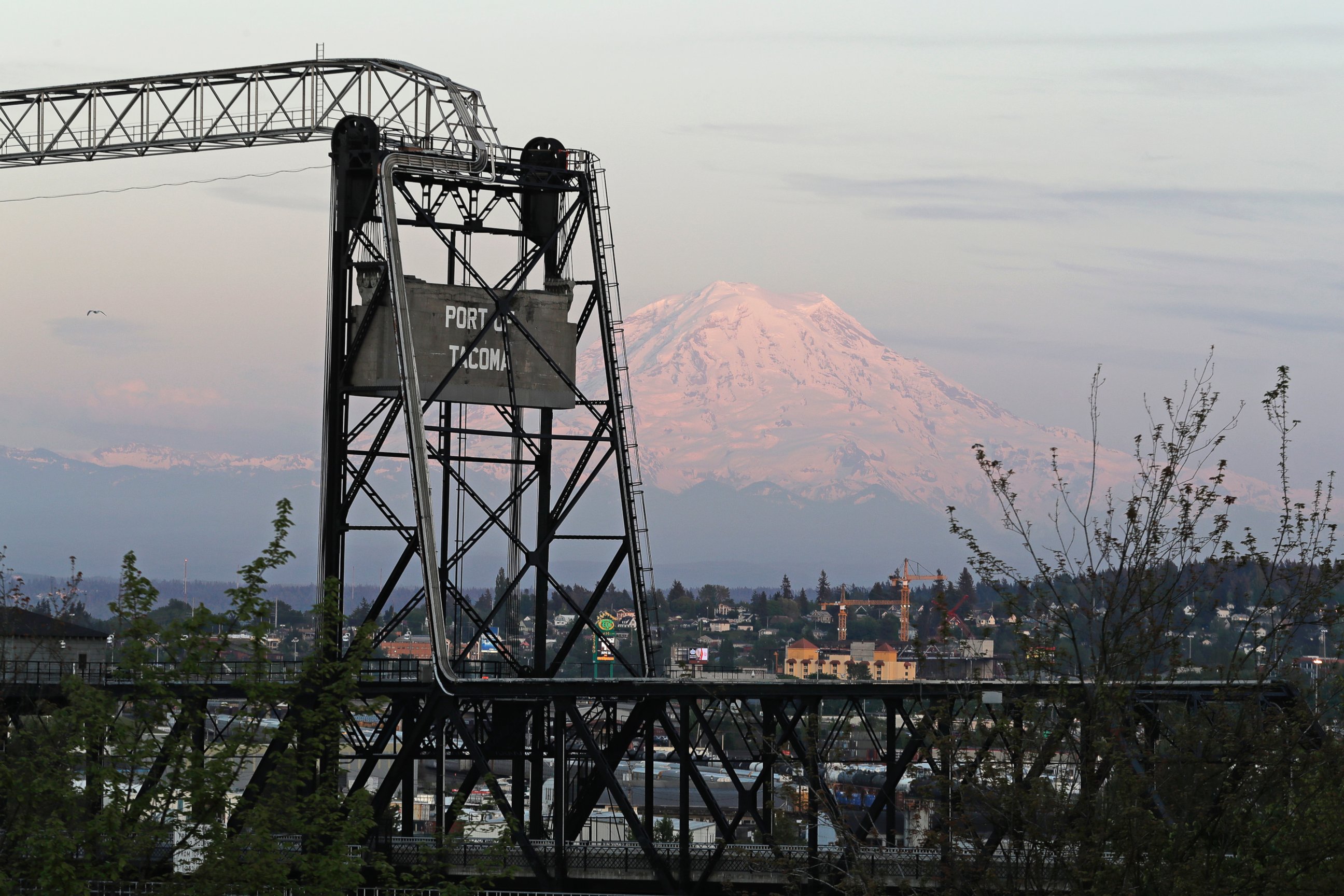 In this May 7, 2018 photo, Mount Rainier is seen at dusk behind the Murray Morgan Bridge in downtown Tacoma, Wash. 