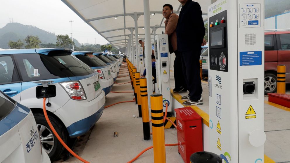 In this Monday, Jan. 7, 2019, photo, new electric-powered taxis are charged at a public charging station in Shenzhen city, south China's Guangdong province. One of China's major cities has reached an environmental milestone, an almost all electric-po