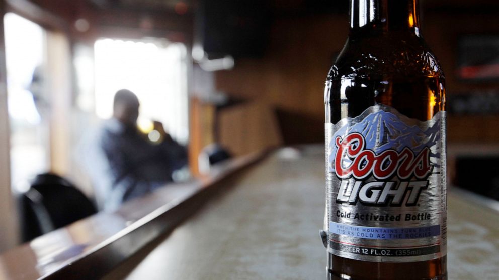 FILE - In this Monday, May 4, 2009, file photo, a bottle of Coors Light sits on the bar as a patron sips a beer at a tavern in Blue Island, Ill. Molson Coors Beverage Co. says it has been hit by a cyberattack that disrupted its brewing operations and