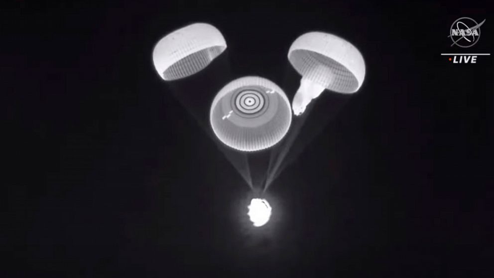 This image provided by NASA shows three of the four parachutes deploying on a cargo ship returning on Jan. 24, 2022. SpaceX and NASA are investigating a parachute issue that occurred on the last two capsule flights. One of the four main parachutes wa