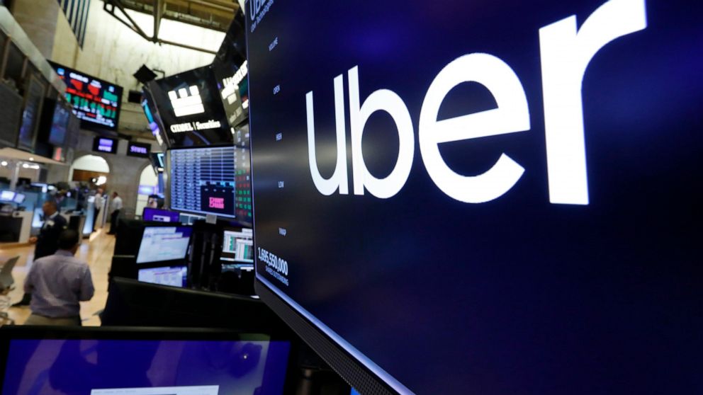 FILE - The logo for Uber appears above a trading post on the floor of the New York Stock Exchange, Friday, Aug. 9, 2019. Uber’s ride-hailing service continued to gain momentum in the second quarter as consumers headed back to offices and started trav