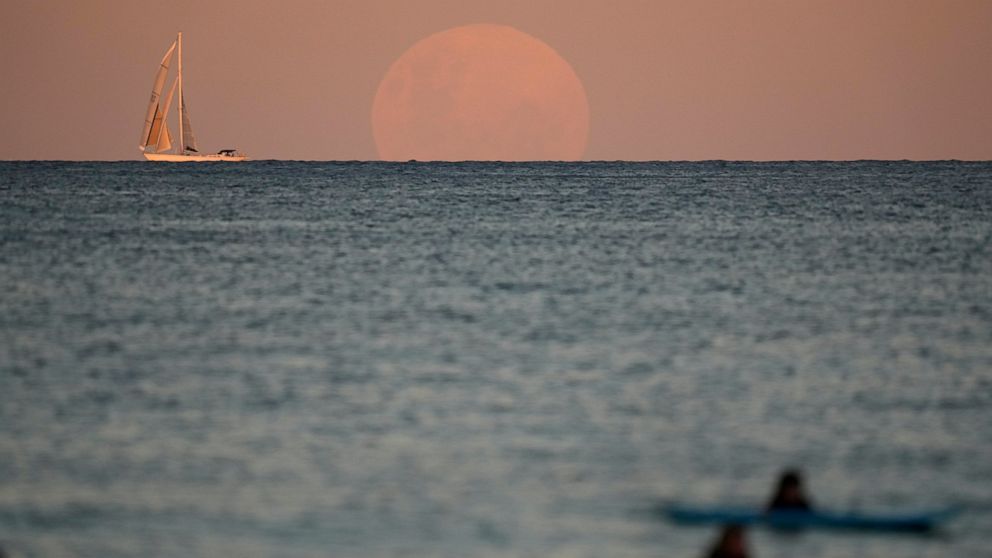 Glittering moon rises ahead of super blood moon