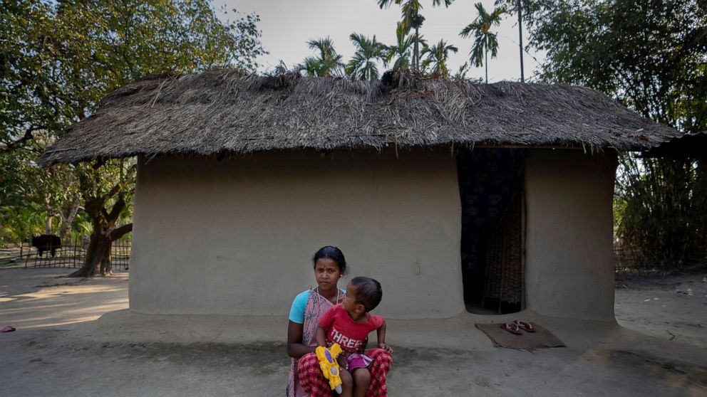 Champa Timungi, 25, sits outside her home in Mikir Bamuni village, Nagaon district, northeastern Assam state, India, Feb. 18, 2022. Timungi said she was beaten by the police despite being pregnant during a protest against the transfer of her family's