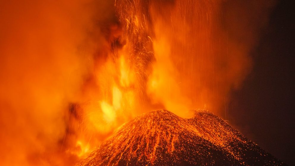 Lava and smoke are belched out from a crater as seen from the north-east side of the Mt Etna volcano near Milo, Sicily, Wednesday night, Feb. 24, 2021. Europe's most active volcano has been steadily erupting since last week, belching smoke, ash, and 