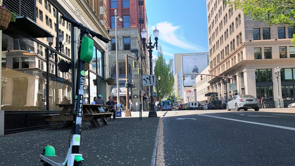 A Lime e-scooter sits parked on a street in downtown Portland, Ore., Thursday, May 9, 2019. A disability rights nonprofit group in Oregon filed a letter of complaint Thursday with the city of Portland over new rules about an electric scooter pilot pr