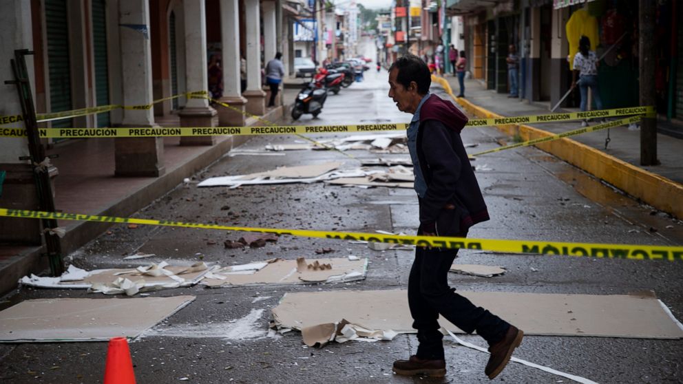 A resident walks through a street cordoned off amid debris from the previous day's earthquake in Coalcoman, Michoacan state, Mexico, Tuesday, Sept. 20, 2022. The magnitude 7.6 earthquake shook Mexico’s central Pacific coast on Monday, killing at leas