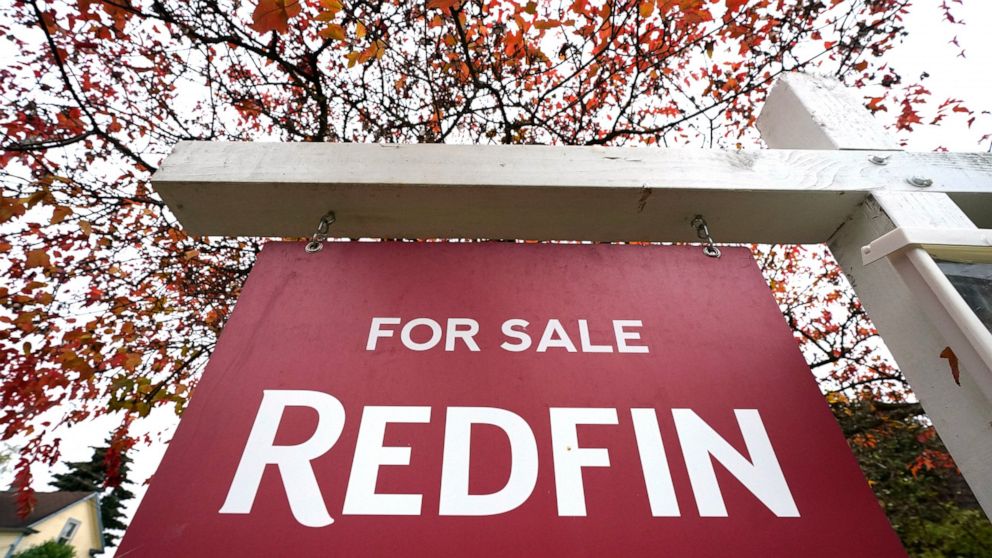 FILE - A Redfin "for sale" sign stands in front of a house on Oct. 28, 2020, in Seattle. The Seattle-based real estate brokerage says it will lay off 8% of its employees as the housing market cools off, Tuesday, June 14, 2022. (AP Photo/Elaine Thomps