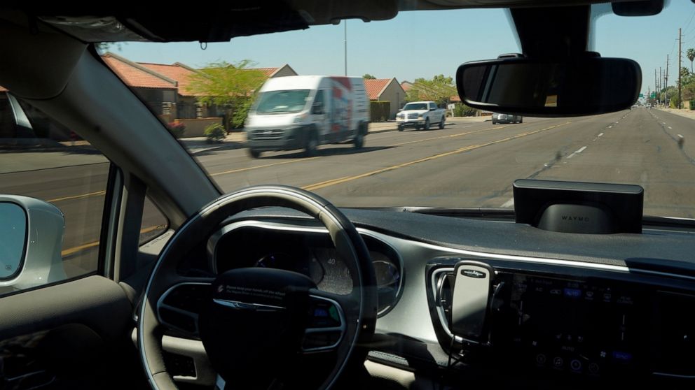 FILE - In this April 7, 2021 file photo, a Waymo minivan moves along a city street as an empty driver's seat and a moving steering wheel drive passengers during an autonomous vehicle ride in Chandler, Ariz. A small maker of autonomous vehicle systems